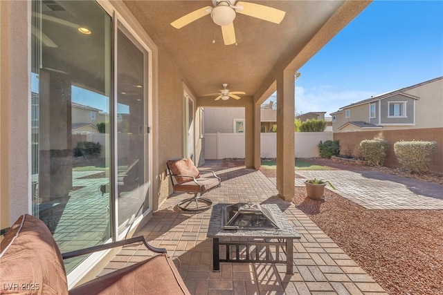 view of patio with ceiling fan and an outdoor fire pit