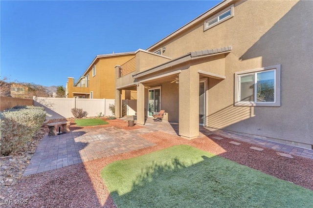 rear view of property featuring a patio area and ceiling fan