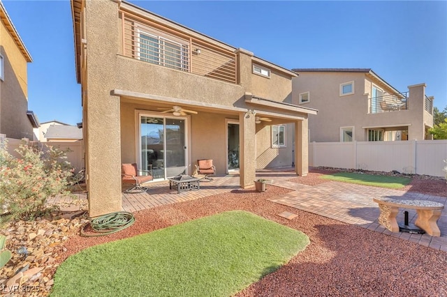 rear view of property with ceiling fan and a patio