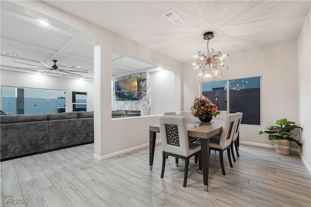 dining room with beam ceiling, coffered ceiling, and ceiling fan with notable chandelier