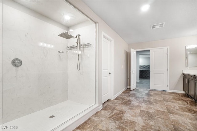 bathroom featuring tiled shower and vanity