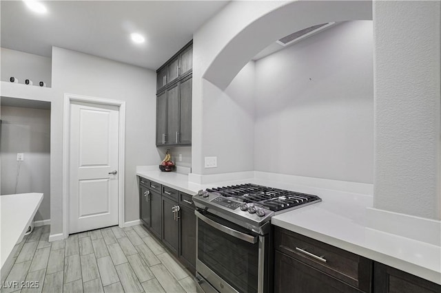 kitchen with stainless steel gas stove and dark brown cabinetry