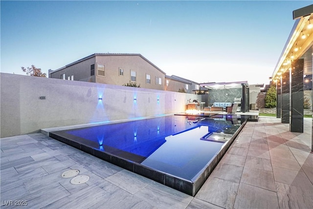 pool at dusk with a patio area