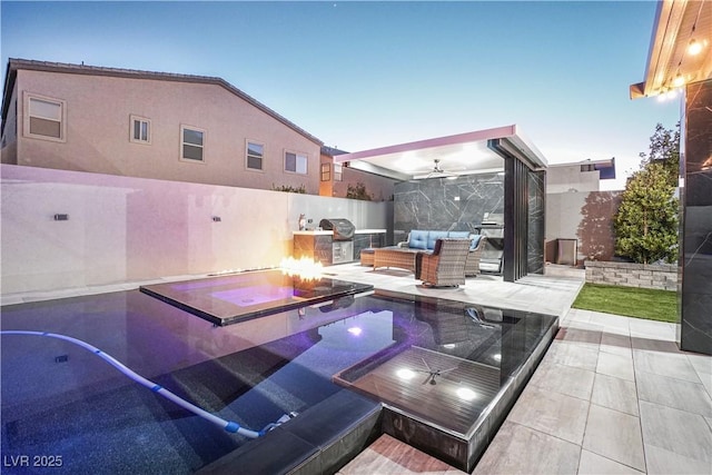 patio terrace at dusk with an outdoor living space with a fire pit