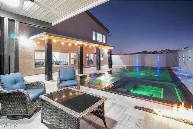 exterior space featuring an outdoor fire pit and a pool with hot tub