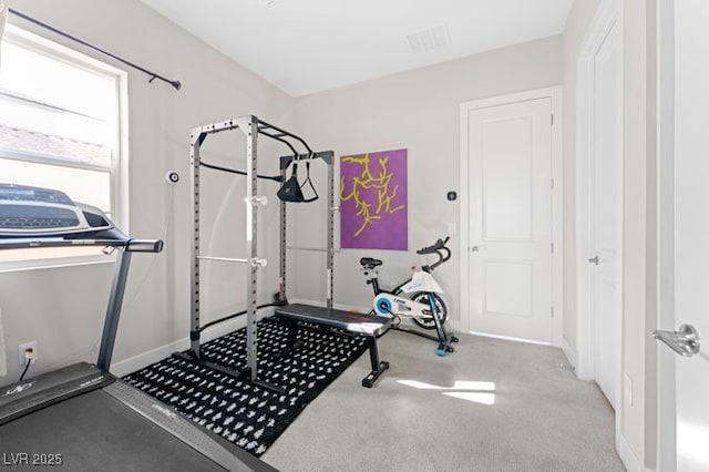 exercise area with light carpet, visible vents, and baseboards