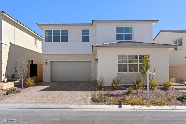 view of front of home with an attached garage, decorative driveway, and stucco siding