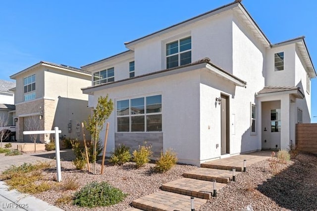 view of front of home featuring fence and stucco siding