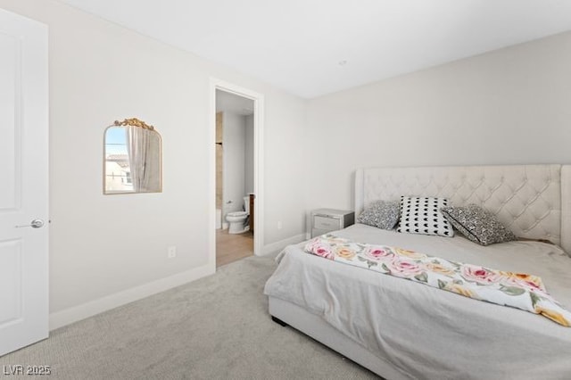 bedroom featuring light carpet, ensuite bath, and baseboards