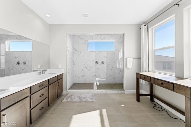 full bathroom featuring a sink, a marble finish shower, and a wealth of natural light