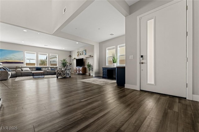 unfurnished living room with recessed lighting, wood finished floors, a wealth of natural light, and baseboards