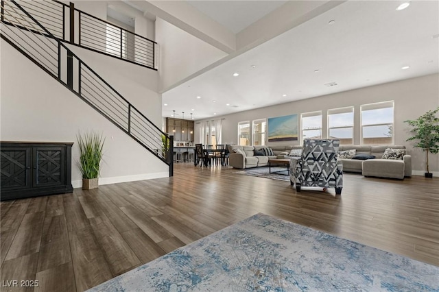 living room with baseboards, stairway, dark wood-style flooring, and recessed lighting