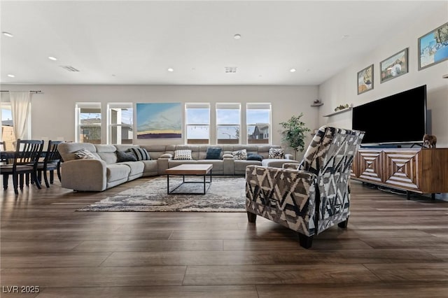 living room with dark wood-style floors, visible vents, and recessed lighting