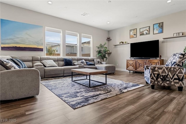 living area featuring baseboards, wood finished floors, visible vents, and recessed lighting