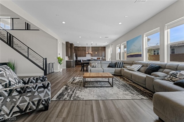 living room featuring stairs, wood finished floors, and recessed lighting