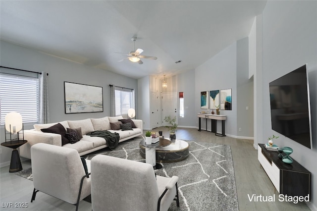 living room with hardwood / wood-style flooring, ceiling fan, and lofted ceiling