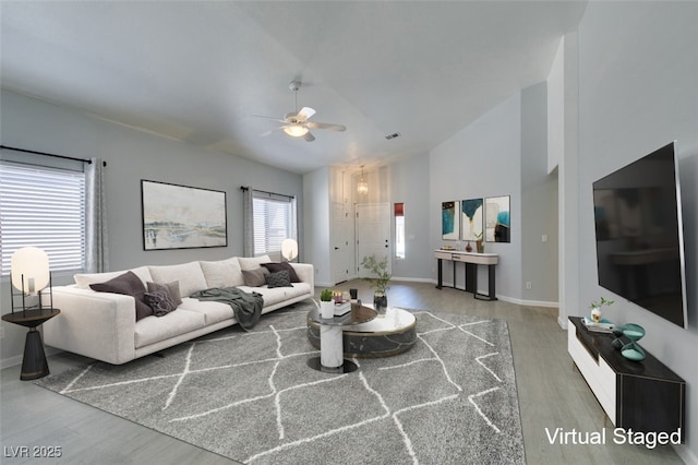 living room featuring ceiling fan, high vaulted ceiling, and hardwood / wood-style flooring