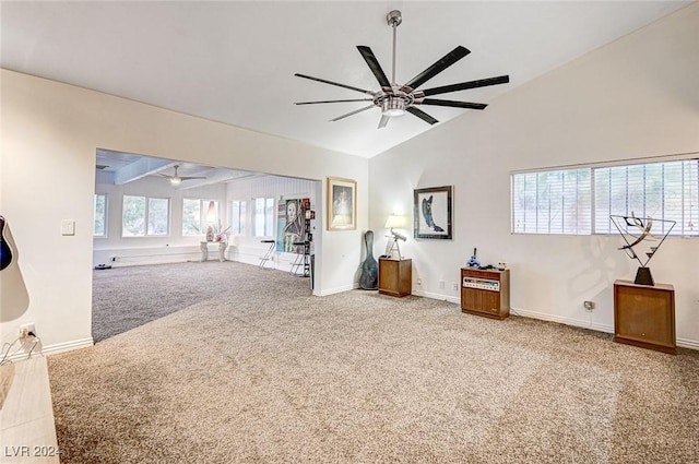 interior space featuring lofted ceiling, carpet flooring, baseboards, and ceiling fan