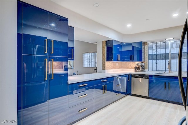 kitchen with stainless steel dishwasher, sink, blue cabinetry, and light hardwood / wood-style flooring