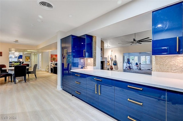 kitchen featuring decorative backsplash, light wood-type flooring, blue cabinets, and ceiling fan