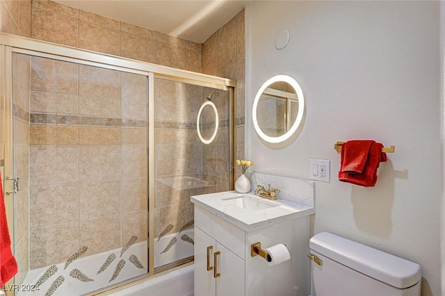 full bathroom featuring vanity, toilet, and shower / bath combination with glass door