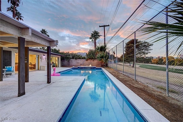 pool at dusk with a patio