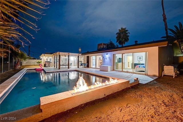 pool at night with a patio area