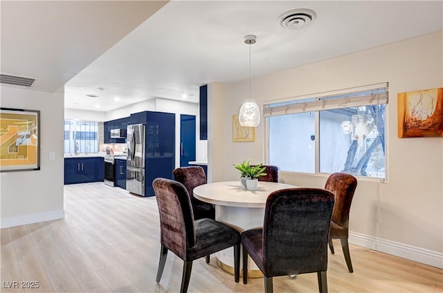 dining space with visible vents, baseboards, and light wood-style floors