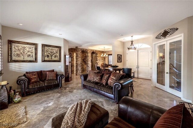 living room featuring french doors and an inviting chandelier