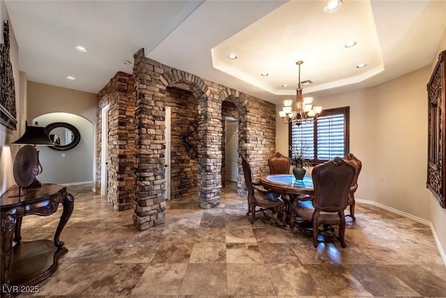 dining room featuring a raised ceiling and an inviting chandelier