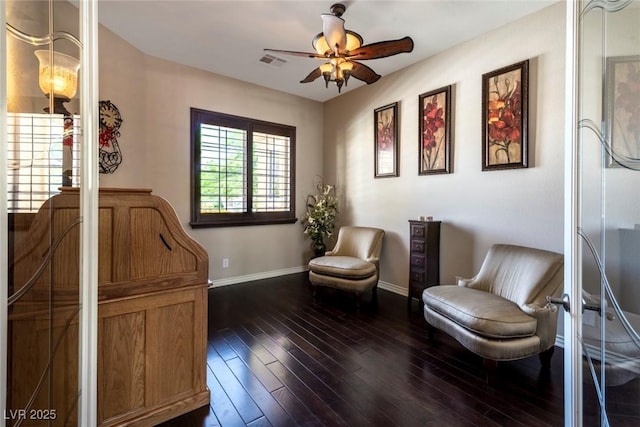 living area featuring ceiling fan and dark wood-type flooring