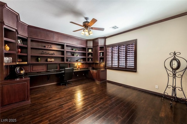 office area featuring ceiling fan, crown molding, dark wood-type flooring, built in desk, and built in features