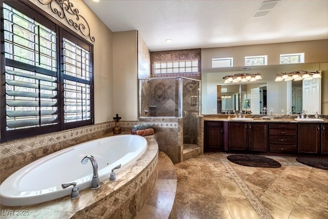 bathroom with a wealth of natural light, vanity, and plus walk in shower