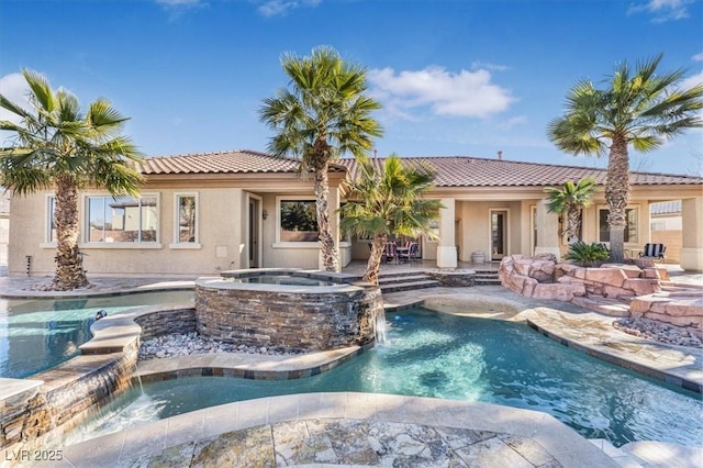 view of pool with an in ground hot tub and pool water feature