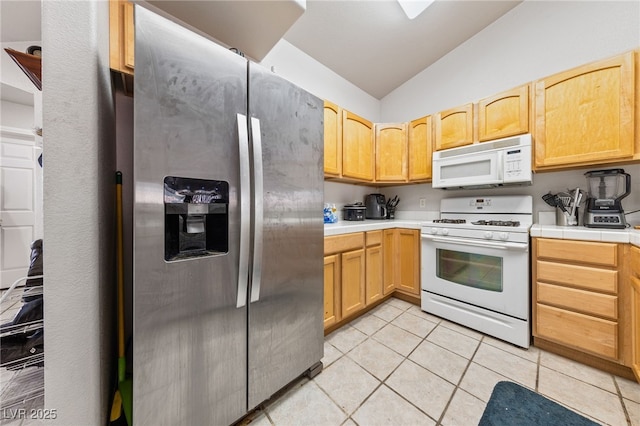 kitchen with lofted ceiling, light brown cabinets, light tile patterned floors, and white appliances