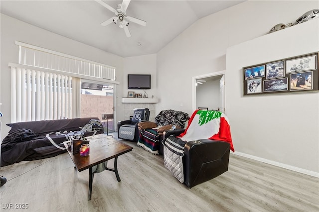 living room featuring ceiling fan, light wood-type flooring, and lofted ceiling