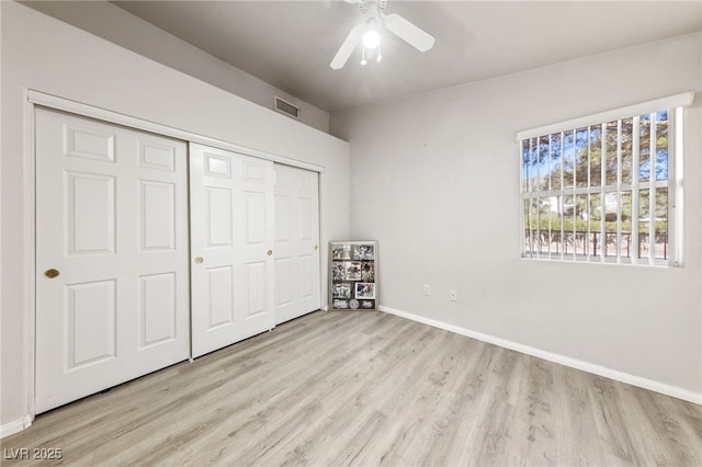 unfurnished bedroom with light hardwood / wood-style flooring, a closet, and ceiling fan