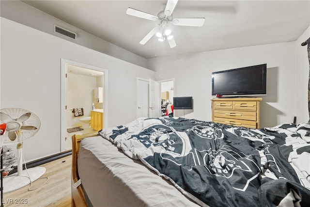 bedroom featuring connected bathroom, ceiling fan, wood-type flooring, and vaulted ceiling