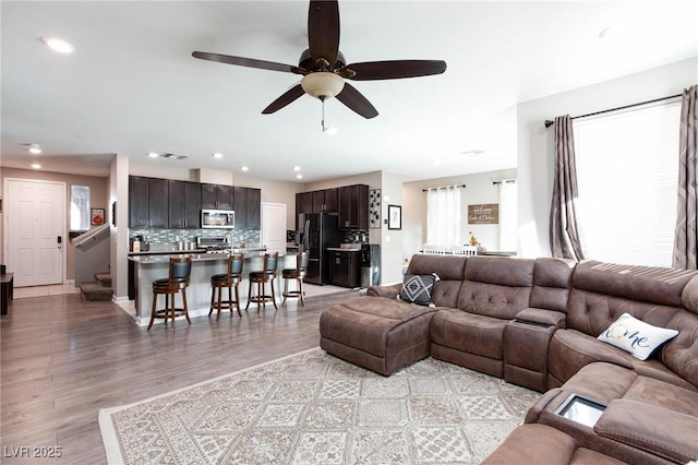 living room featuring ceiling fan and light hardwood / wood-style floors