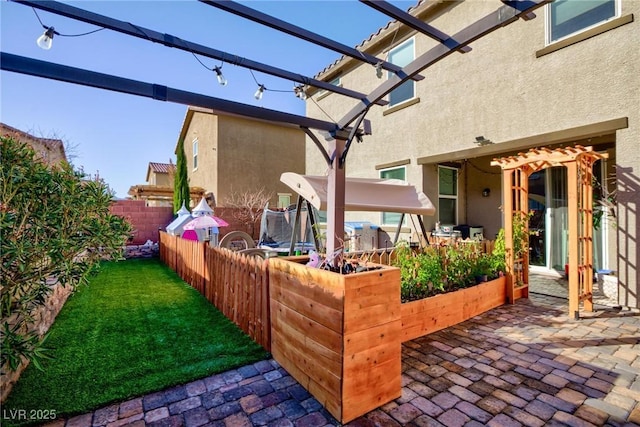 view of patio featuring a trampoline and a pergola