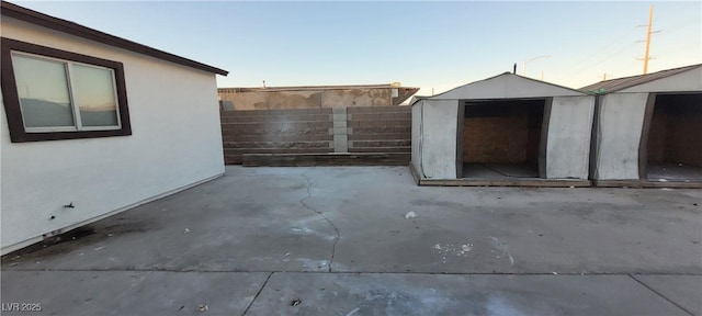 patio terrace at dusk featuring a storage unit