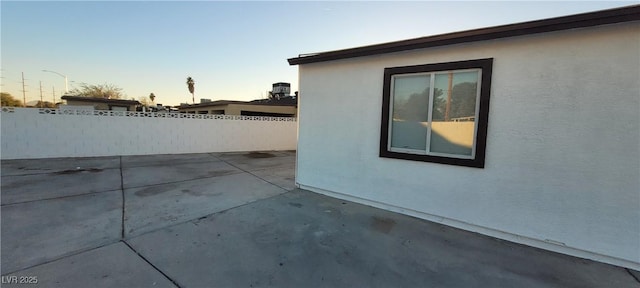 property exterior at dusk featuring a patio area