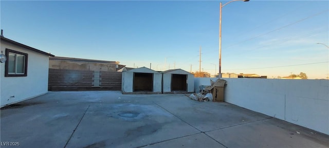 patio terrace at dusk featuring a storage shed