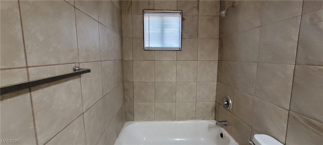 bathroom featuring toilet and tiled shower / bath combo