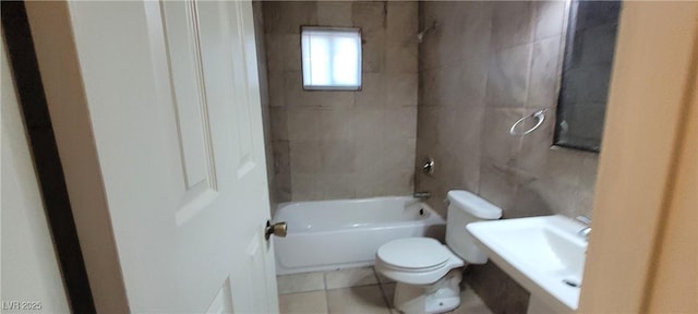 full bathroom featuring toilet, tile patterned floors, tiled shower / bath, and sink