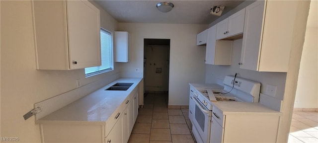 kitchen featuring light tile patterned floors, white electric stove, white cabinets, and sink