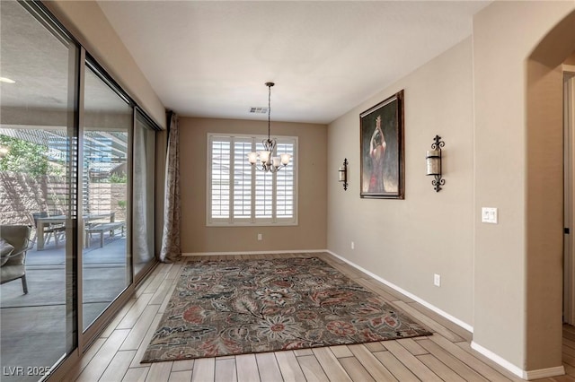 unfurnished dining area featuring a notable chandelier and hardwood / wood-style flooring