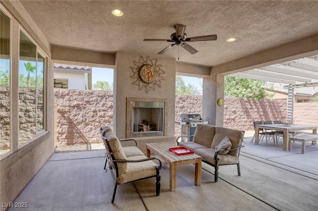 view of patio / terrace featuring an outdoor living space with a fireplace, area for grilling, and ceiling fan