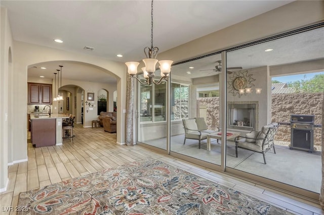 dining area with sink and ceiling fan with notable chandelier