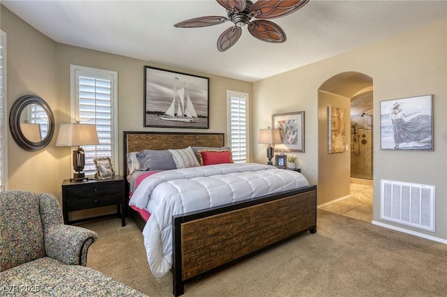 carpeted bedroom with ceiling fan and ensuite bathroom